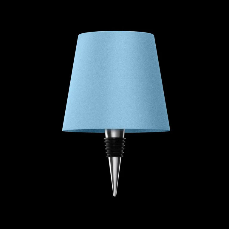 AMBIENTIFY Bottle wireless LED lamp fitted onto a wine bottle, placed on an outdoor garden table surrounded by natural greenery. Soft warm ambient glow, touch-dimmable in 3 levels, USB-C rechargeable table lamp for home décor.