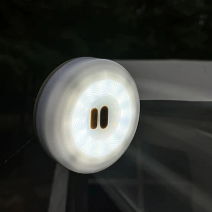 Campify String fairy light reel held in hand at night, showing warm amber LED string lights extended across dark outdoor ground, compact hub glowing with blue charge indicator, IP67 waterproof camping and home fairy lights.