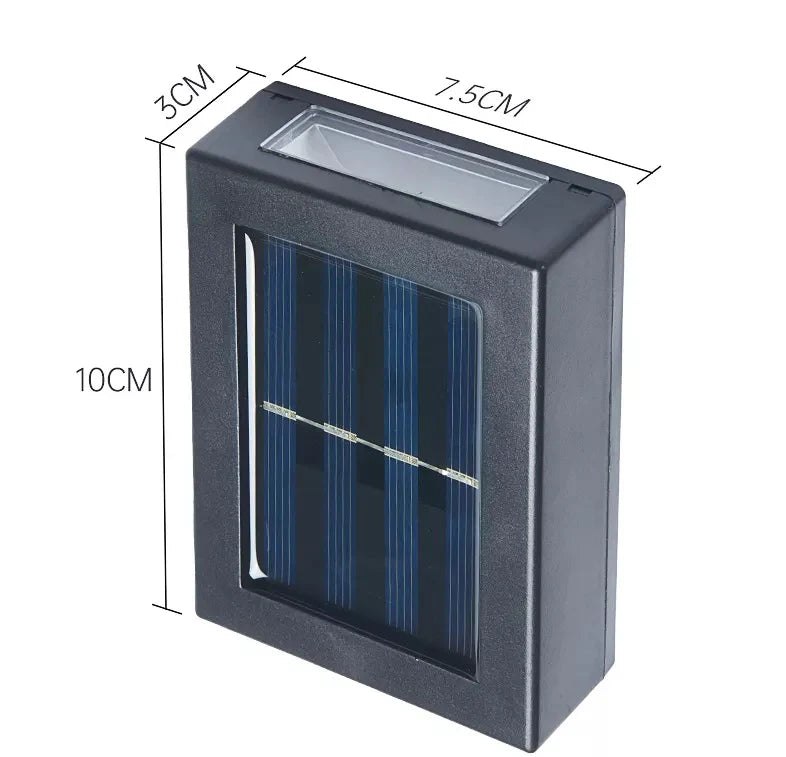 SOLARIFY One solar-powered outdoor wall light mounted on a stone wall, projecting warm white light upward and downward. IP65 weatherproof. Suitable for garden fences, façades, covered terraces and entrance walls.